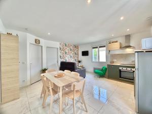 a kitchen and a living room with a table and chairs at Escapade Gîte Seryse in Châtillon-sur-Broué +11 photos