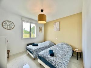a bedroom with two beds and a window at Escapade Gîte Seryse in Châtillon-sur-Broué