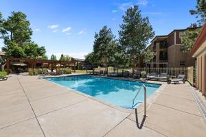 a swimming pool in a yard with chairs and trees at Flatirons Hideaway in Boulder CO in Boulder
