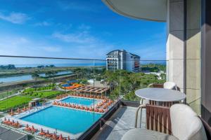 a view of the pool and ocean from the balcony of a hotel at Trendy Perge Resort & Suites in Aksu