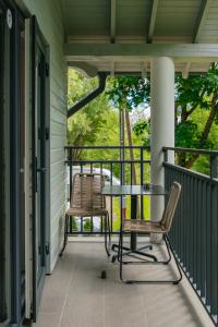 a patio with a table and chairs on a porch at NEMIRSETA FOREST Apartments in Palanga