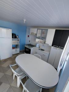 a kitchen with a white table and white appliances at Pousada Por do Sol in Lapa