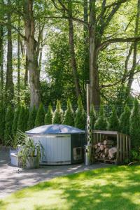 a hot tub in a yard next to trees at NEMIRSETA FOREST Apartments in Palanga