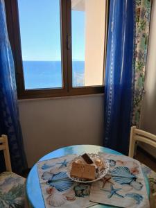 a plate of food on a table in front of a window at Palazzo tre palme in Follonica +4 photos