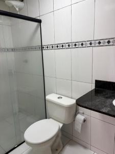 a white bathroom with a toilet and a shower at Pequena Sereia Guriri in São Mateus +26 photos