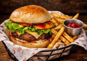 a basket with a hamburger and french fries with ketchup at Island Lyfe Adventures Hotel - 5 Minutes from El Nido Airport & Lio Beach in El Nido
