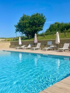 a swimming pool with lounge chairs and umbrellas at La Cà dOlga in La Morra