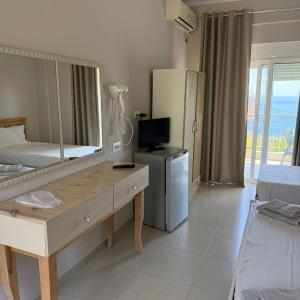 a bedroom with a mirror and a dresser and a bed at La Maroja View Hotel in Dhërmi +63 photos