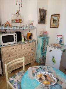 a small kitchen with a table and a microwave at Palazzo tre palme in Follonica