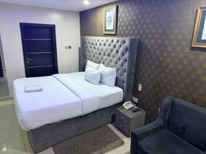 a hotel room with a bed and a chair at NO 95 Suites LEKKI PHASE 1 in Ilado