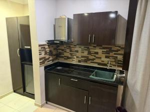 a small kitchen with a sink and a refrigerator at NO 95 Suites LEKKI PHASE 1 in Ilado +9 photos