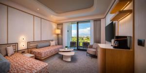 a hotel room with a bed and a tv at Trendy Perge Resort & Suites in Aksu