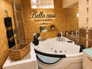 a bathroom with a tub with a sign on the wall at Bella Casa Apartments in Făgăraş