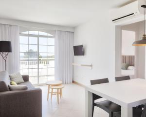 uma sala de estar com um sofá e uma mesa em Ilunion Menorca em Cala Galdana