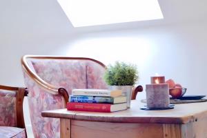 a table with a stack of books and a candle at Ferien- Monteurwohnung in Zülpich in Zülpich +6 photos