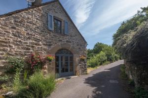 an old stone house with a door on a road at L'ecrin de séraphie in Nojaret