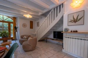 a living room with a staircase and a tv at L'ecrin de séraphie in Nojaret