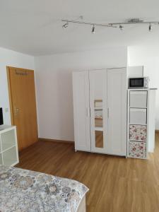 an empty room with white cabinets and a kitchen at Gästezimmer mit eigenem Eingang in Schwäbisch Hall