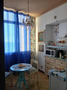 a kitchen with a table and a small table and a microwave at Palazzo tre palme in Follonica