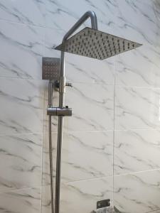 a shower light in a bathroom with white marble walls at Mega Luxury Apartment in Asagba +1 photo