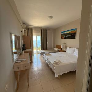 a hotel room with a large bed and a television at La Maroja View Hotel in Dhërmi