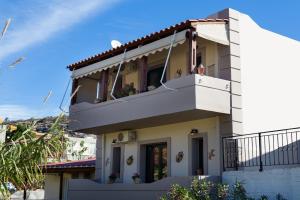 a house with a balcony on top of it at Marathi Apartments in Marathi