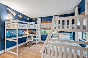 a bedroom with two bunk beds and blue walls at Surf Drive - Ultimate Beach Getaway for Families in Cocoa Beach
