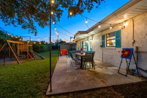 a patio with a table and chairs and a playground at Surf Drive - Ultimate Beach Getaway for Families in Cocoa Beach