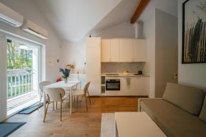 a kitchen and living room with a table and chairs at NEMIRSETA FOREST Apartments in Palanga +36 photos