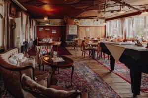 a dining room with tables and chairs and a grand piano at Gasthaus Fuchsacker in Degersheim