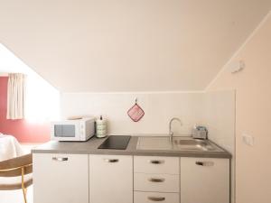 a kitchen with a sink and a microwave at Le camere di Gaudré in Battipaglia