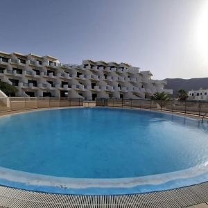 a large swimming pool in front of a hotel at Casa Candy. Piscina, Mar y Paz. in Tuineje