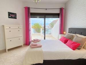 a bedroom with a large bed with pink curtains at Casa Candy. Piscina, Mar y Paz. in Tuineje +41 photos