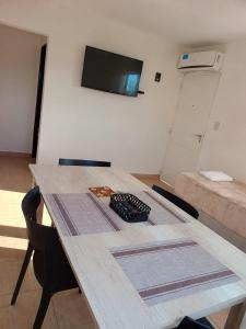 a wooden table in a room with a pizza on it at Complejo Los Arrayanes - Plottier in Plottier