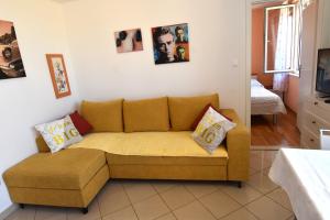 a living room with a yellow couch in a room at Villa NADA 1 in Podgora