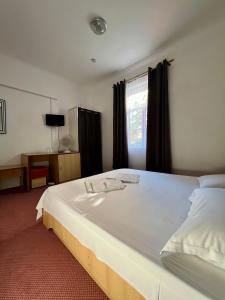 a large white bed in a room with a window at Sinziana Eforie Sud in Eforie Sud