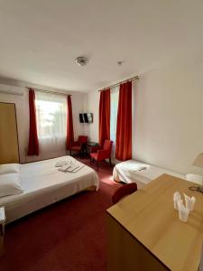 a hotel room with two beds and a desk at Sinziana Eforie Sud in Eforie Sud