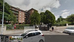 una macchina bianca parcheggiata in un parcheggio accanto a un edificio di Belon B&B poli casilino a Roma