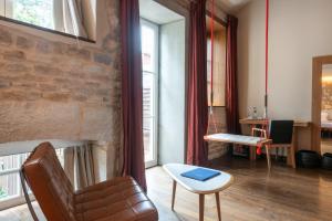 a living room with a chair and a table at Hotel Aux Terrasses in Tournus