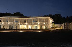 a large white building at night with lights at Luna D'Argento in Leporano Marina