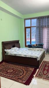 a bedroom with two beds and a window at The Raulane Homestay in Kalpa +5 photos