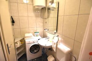 a small bathroom with a washing machine and a sink at Villa NADA 1 in Podgora +18 photos