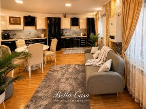 a living room with a couch and a table and chairs at Bella Casa Apartments in Făgăraş