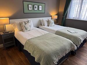 a hotel room with two beds and two lamps at The Farmers Boy Inn Guest House in Longhope