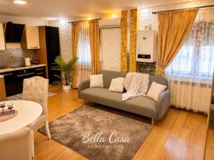 a living room with a couch and a kitchen at Bella Casa Apartments in Făgăraş