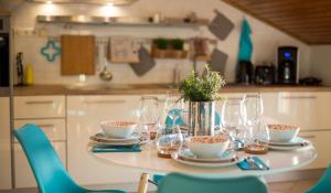 einen Tisch mit Tellern, Gläsern und Blumen darauf in der Unterkunft Apartments MT Residence in Zavalatica