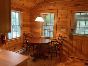 a dining room with a table and chairs in a cabin at Rivers Edge Cabins - Tranquil Nook in Cushing