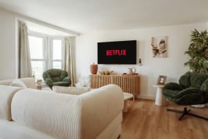 a living room with a couch and a tv at Quayside Apartments, Brixham in Brixham