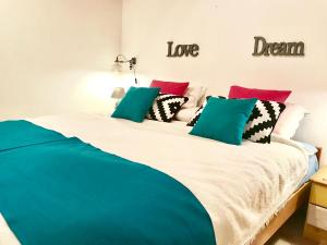 ein Schlafzimmer mit einem großen weißen Bett mit bunten Kissen in der Unterkunft Apartments MT Residence in Zavalatica