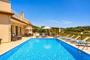 a swimming pool with chaise lounge chairs and a swimming pool at Villa Christel in Lachi